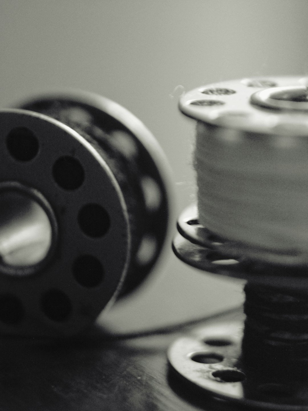 gallery-2 two-sewing-bobbins-one-with-thread-in-black-and-white-ise2njjafjc